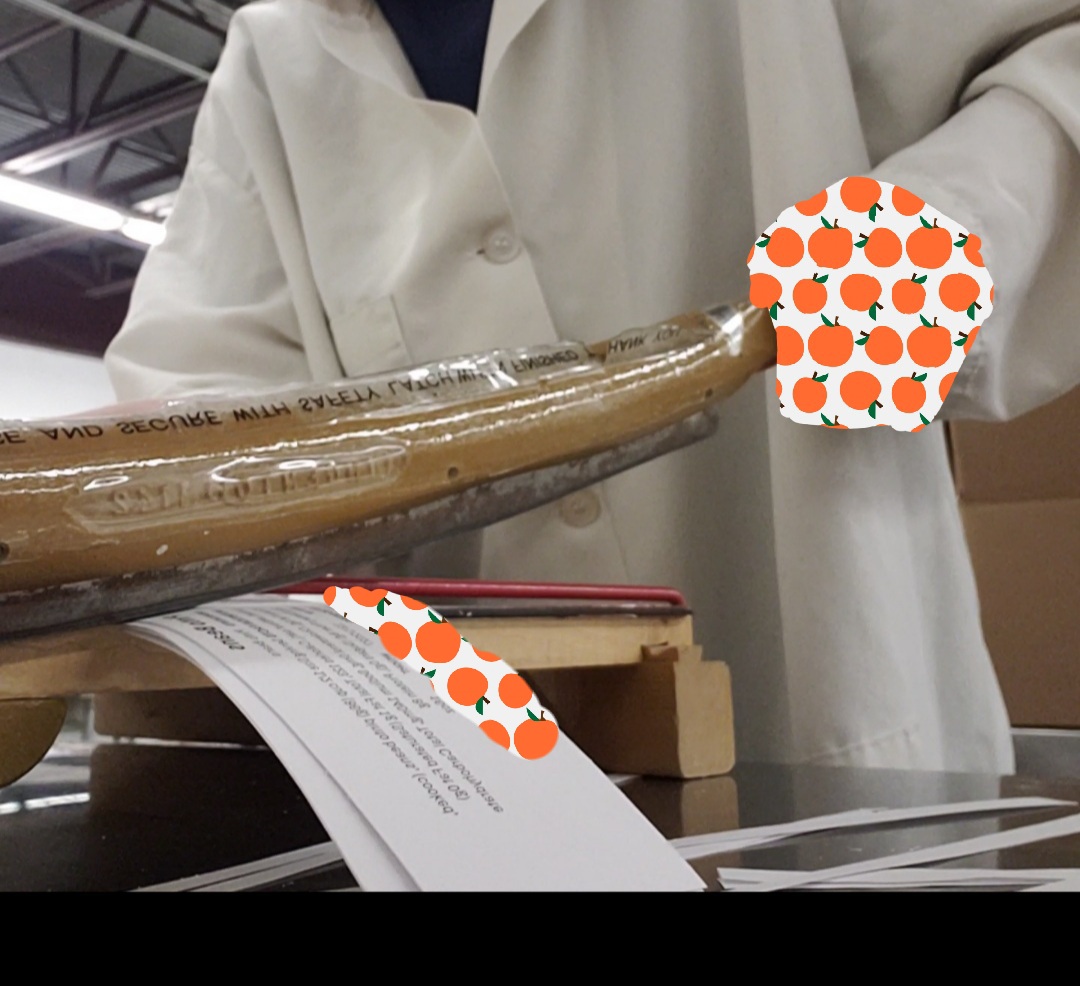 Hand holds handle for label cutter.
